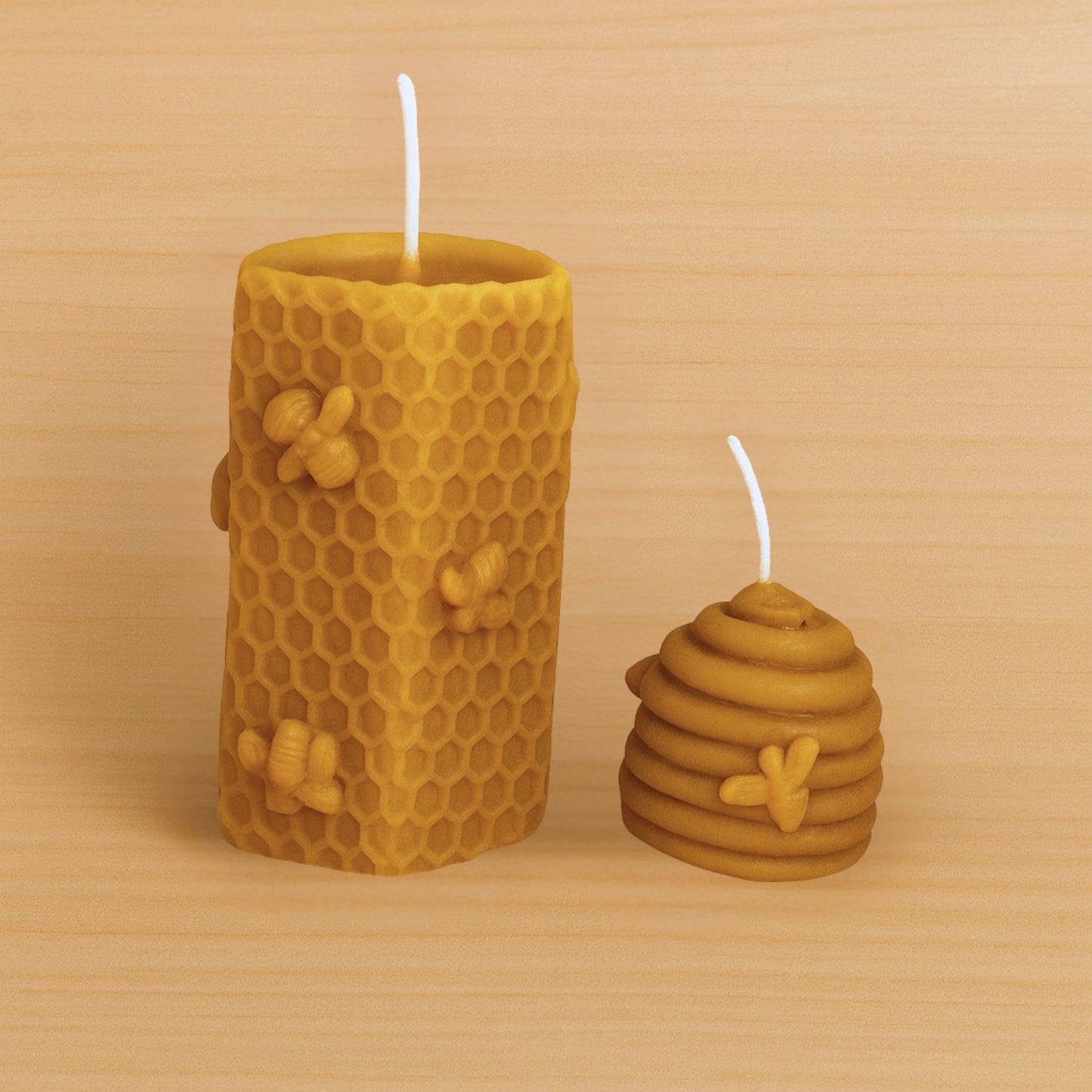 Two yellow honeycomb-shaped candles with bee designs on a wooden surface