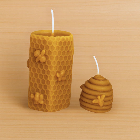 Two yellow honeycomb-shaped candles with bee designs on a wooden surface