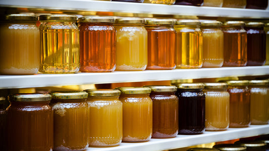 different colored honey jars on a shelf