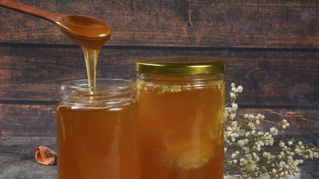 honey dipper dipping in jars of honey 