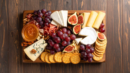 charcuterie board with cheese, honey, figs and grapes