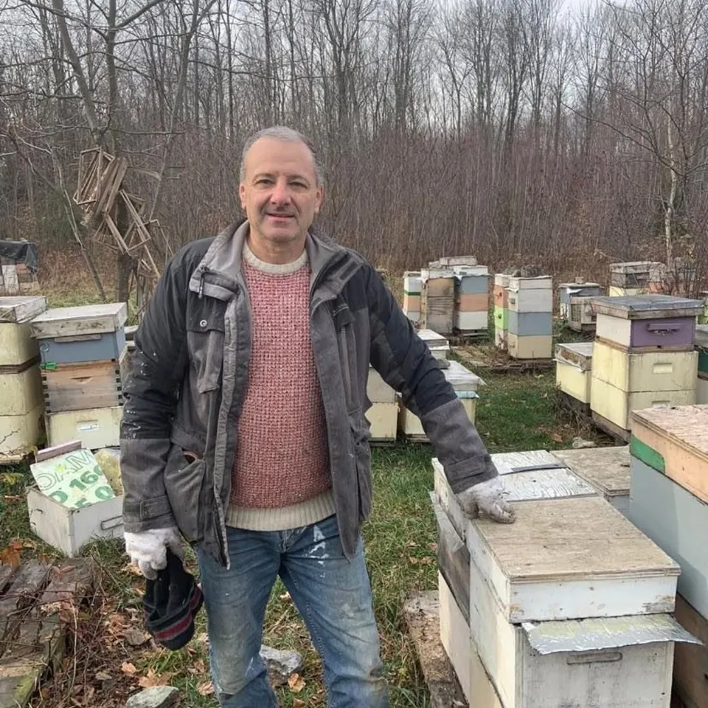 Todor, the master beekeeper behind Miel D'or, standing among his hives